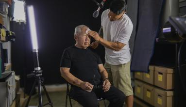 son Tad wiping his elderly father's brow in the studio